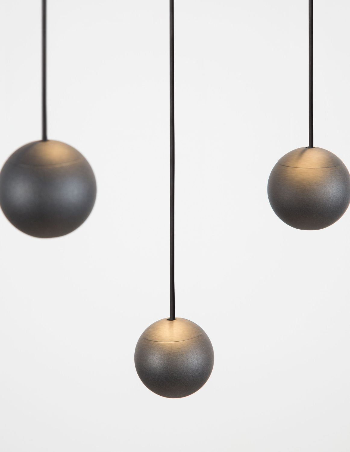 Détail rapproché de trois boules noires au dégradé bronze sur le dessus