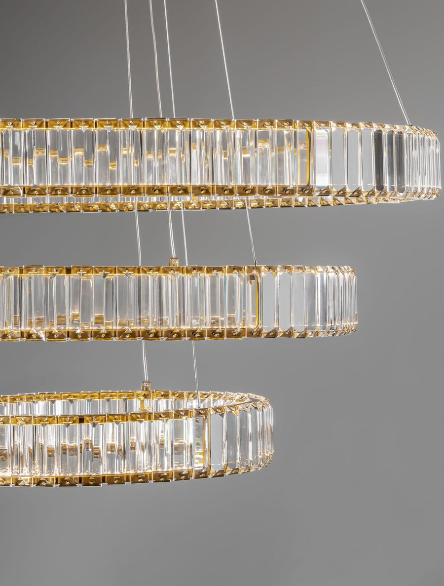 Détail rapproché des anneaux de cristal taillé et de leur armature dorée