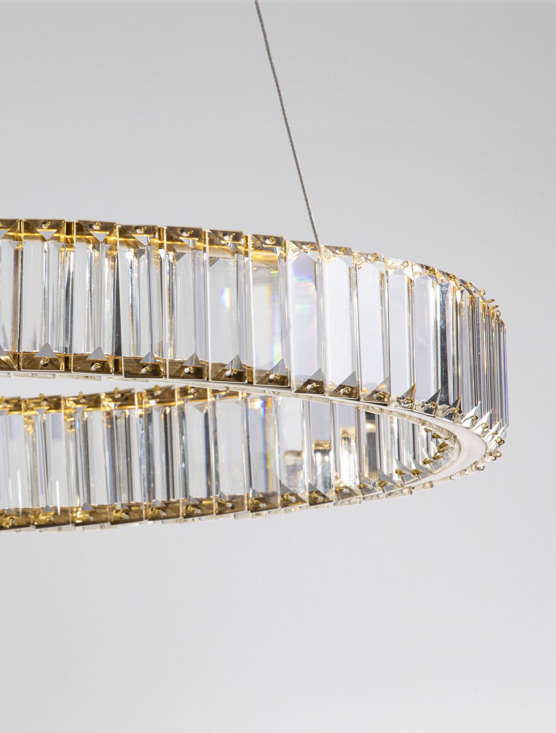 Gros plan sur l'arc de l'anneau, attaches dorées et reflets du cristal
