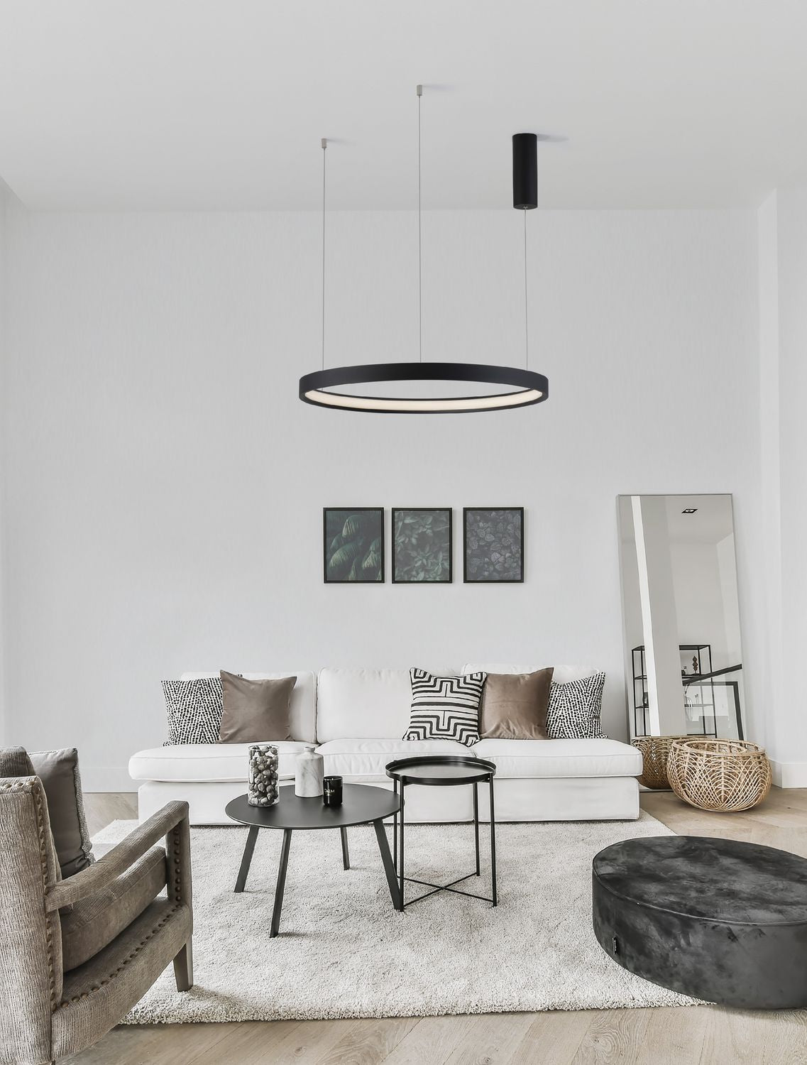 Mise en ambiance d'un salon, suspension anneau noire allumée au-dessus du canapé blanc