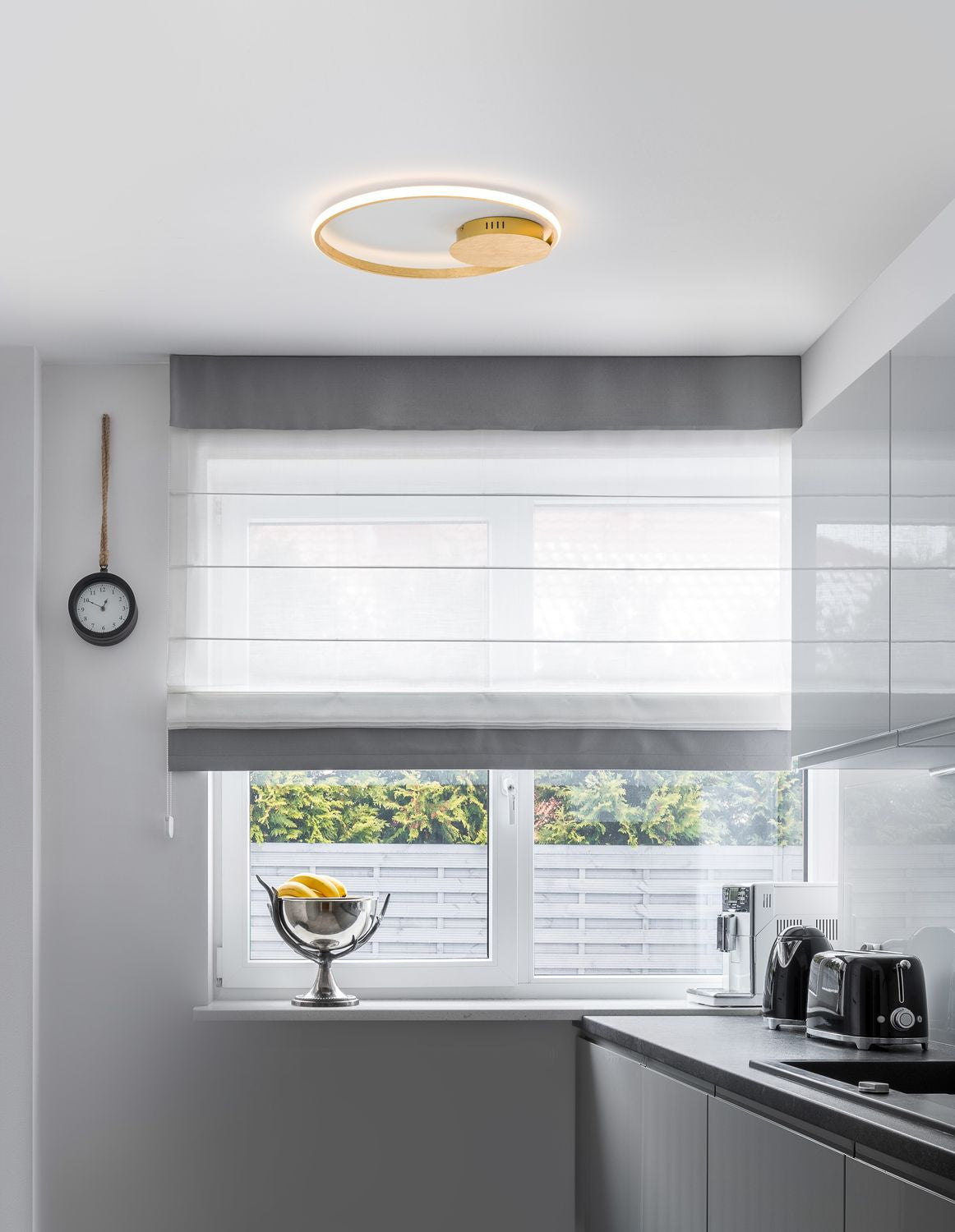 Plafonnier doré allumé au plafond d'une cuisine moderne et lumineuse