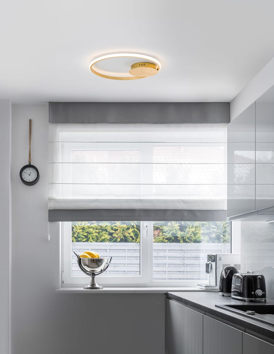 Plafonnier doré allumé au plafond d'une cuisine moderne et lumineuse