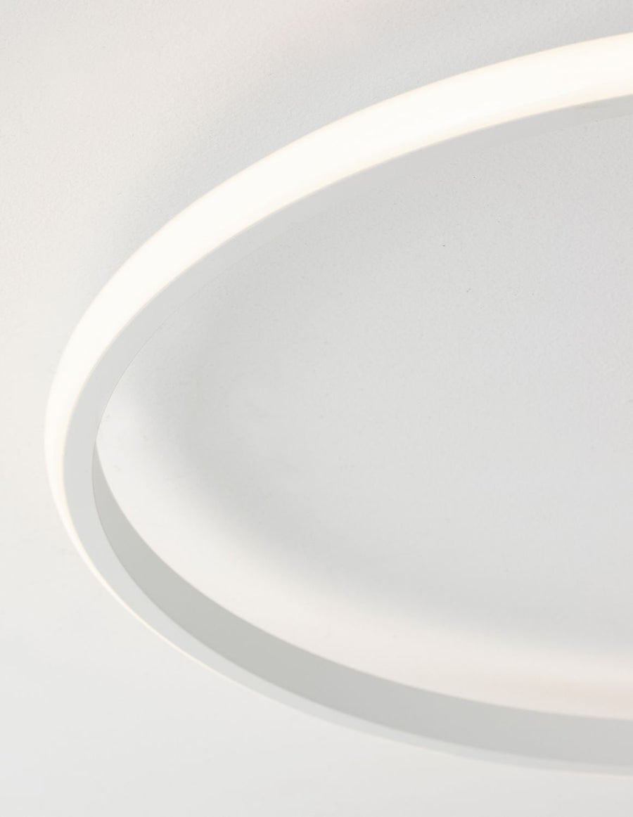 Gros plan sur l'anneau LED blanc allumé, halo lumineux diffus sur le plafond