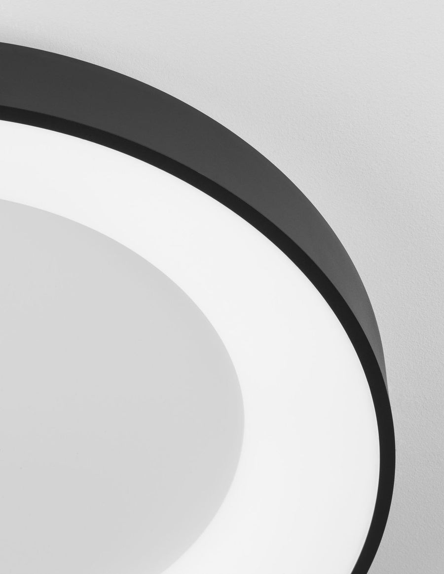 Gros plan sur le bord du luminaire, finition noire mate et diffuseur opalin