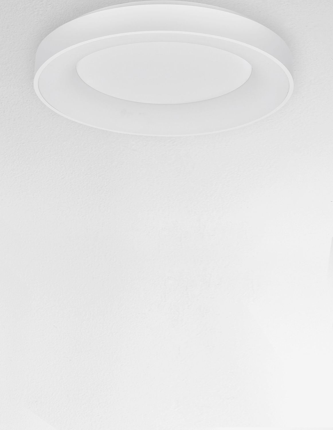 Plafonnier allumé fixé au plafond, halo lumineux diffus blanc