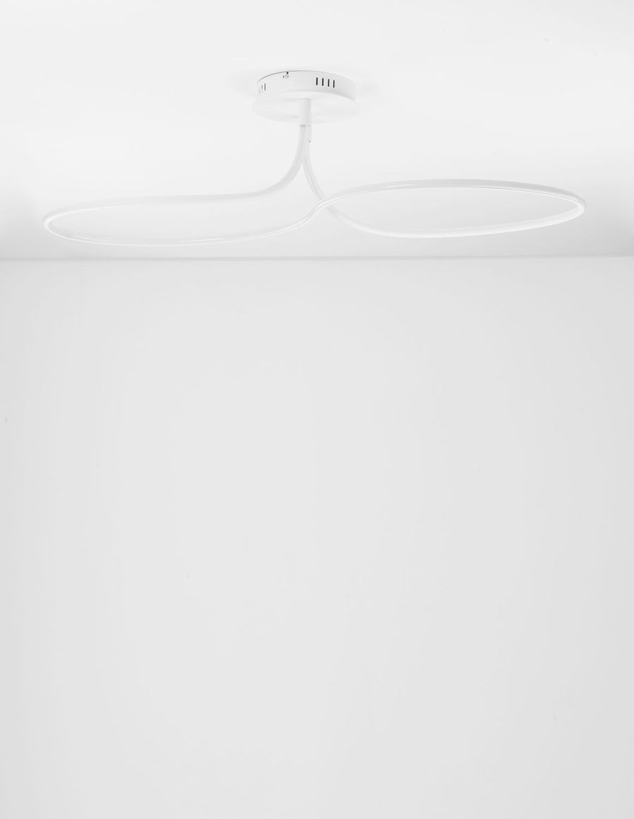Vue plongeante du luminaire allumé, fixé au plafond blanc d'une pièce