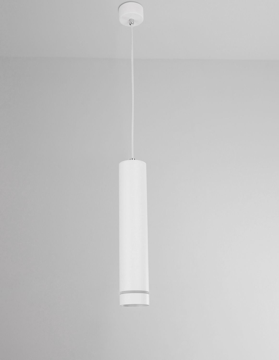 Suspension blanche vue de profil devant un mur gris clair, éclairage éteint