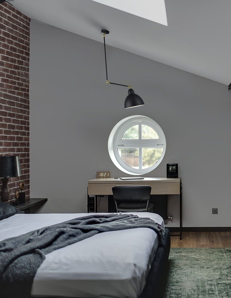 Suspension noire fixée au plafond dans une chambre, éclairant un bureau