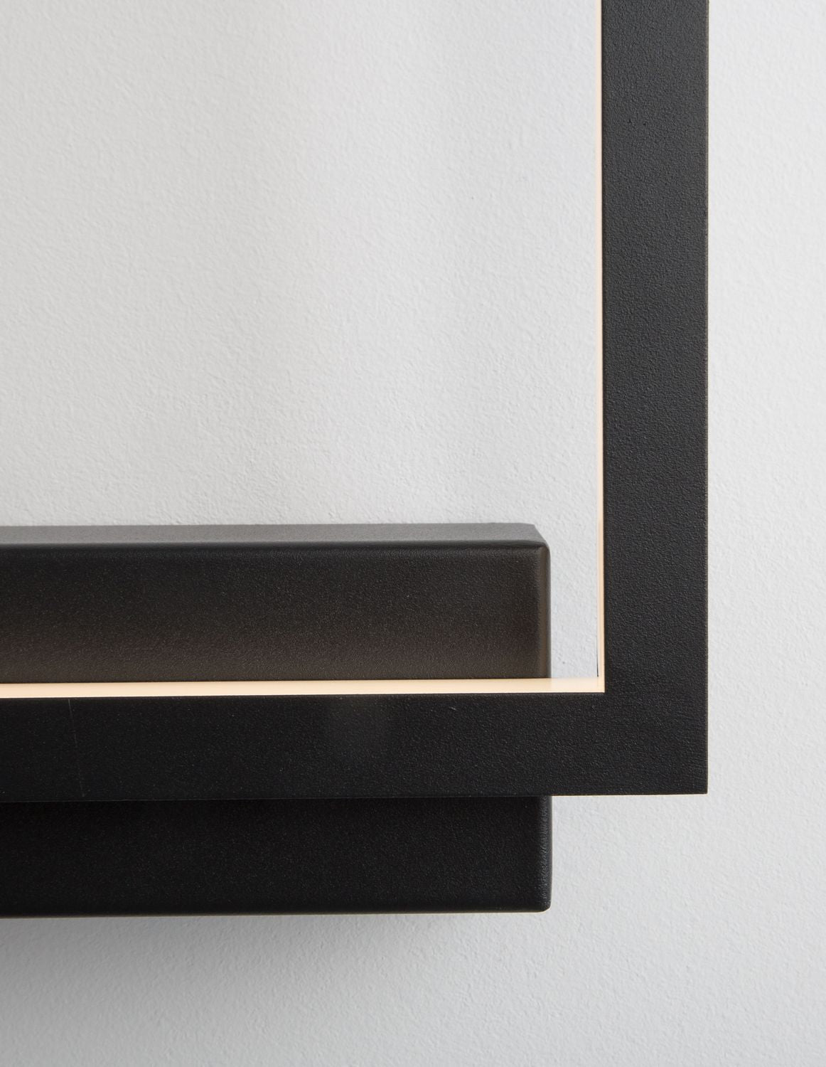 Détail rapproché du coin inférieur droit, finition noire granuleuse et joint lumineux