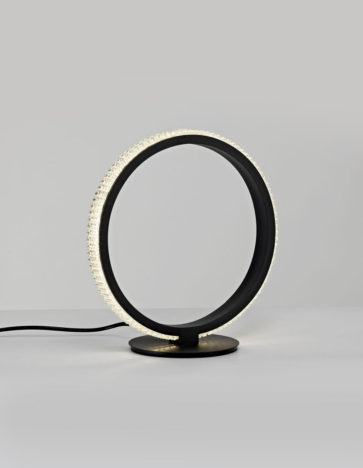 Lampe à poser noire en anneau, vue de face sur fond gris clair