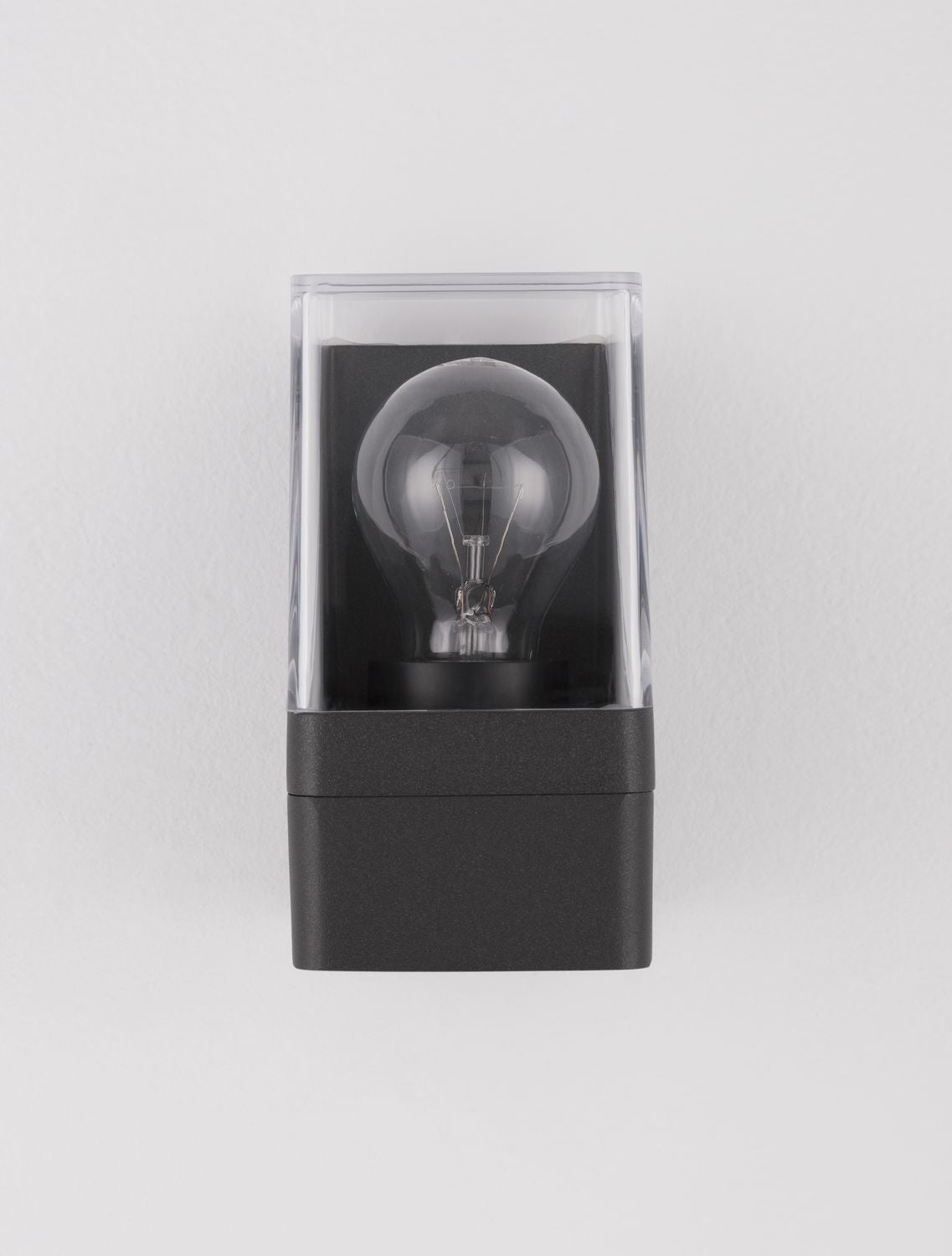 Gros plan frontal, ampoule à filament centrée dans le carré transparent du luminaire
