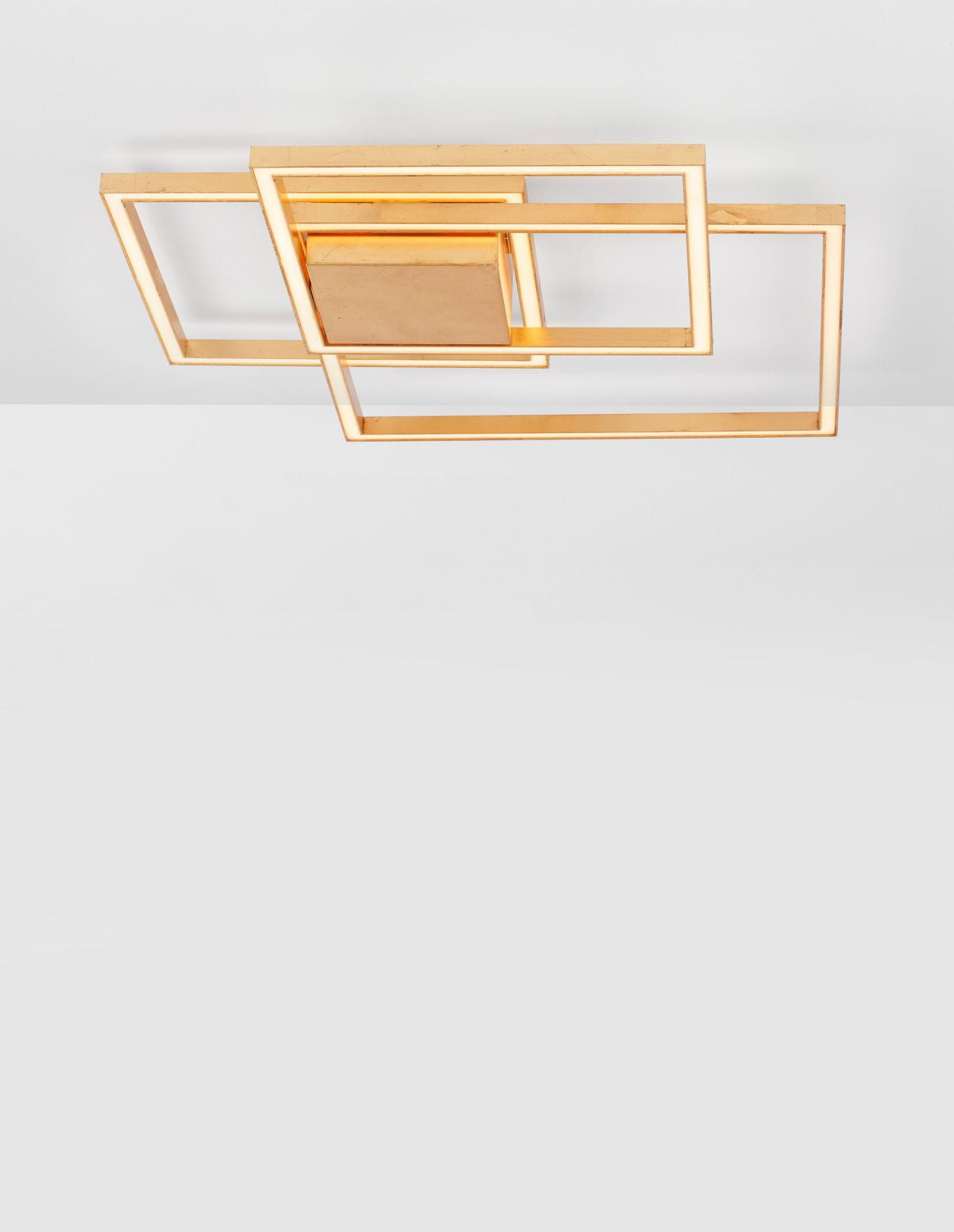 Vue de dessous du plafonnier doré aux trois cadres rectangulaires superposés