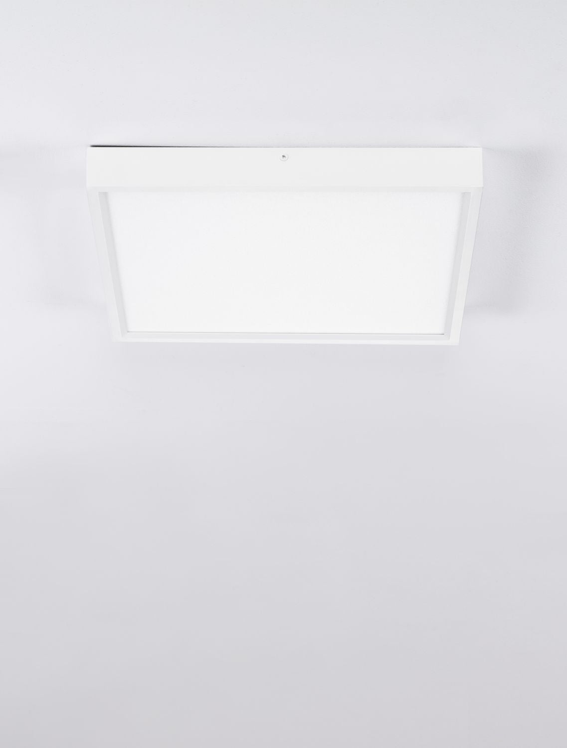 Vue frontale du plafonnier blanc posé au plafond, cadre carré et surface lumineuse uniforme