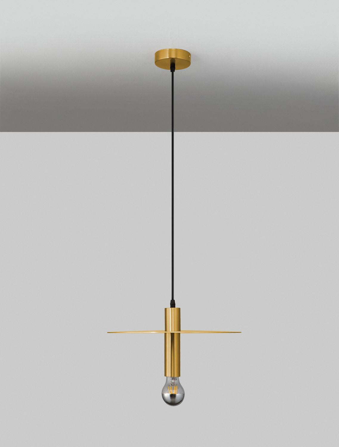 Suspension dorée installée au plafond gris, éclairant la pièce en ambiance.