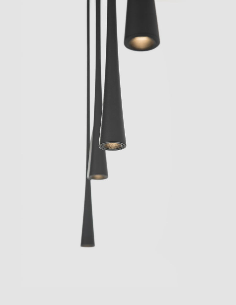 Détail des embouts coniques noirs, intérieur doré et lumière chaude allumée.