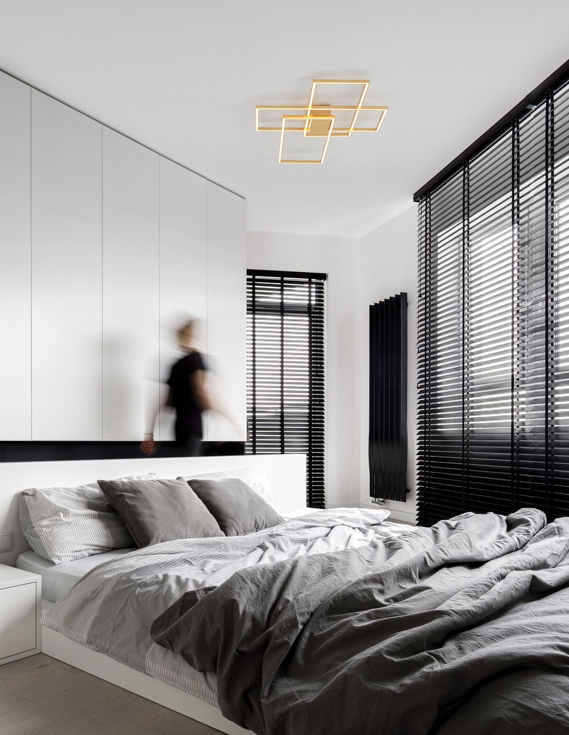 Mise en ambiance d'une chambre moderne avec le plafonnier doré allumé au plafond