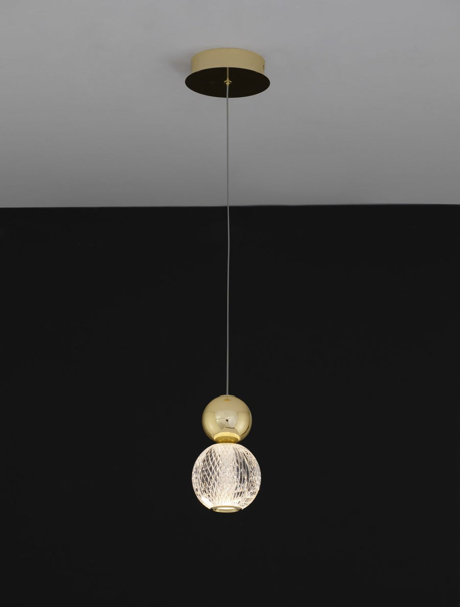 Suspension allumée sur fond noir, lumière tamisée par le verre