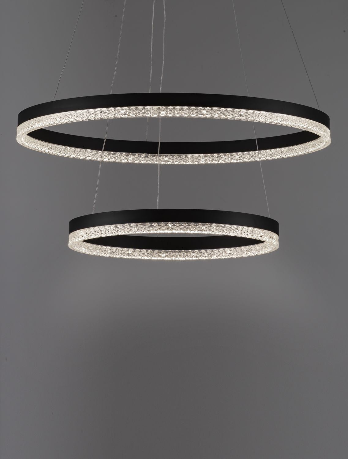 Gros plan sur les anneaux lumineux et la finition cristalline de la suspension.