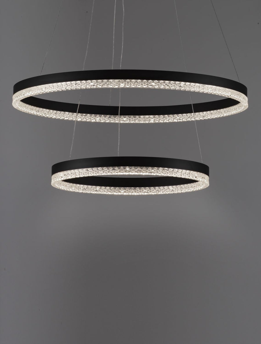 Gros plan sur les anneaux lumineux et la finition cristalline de la suspension.