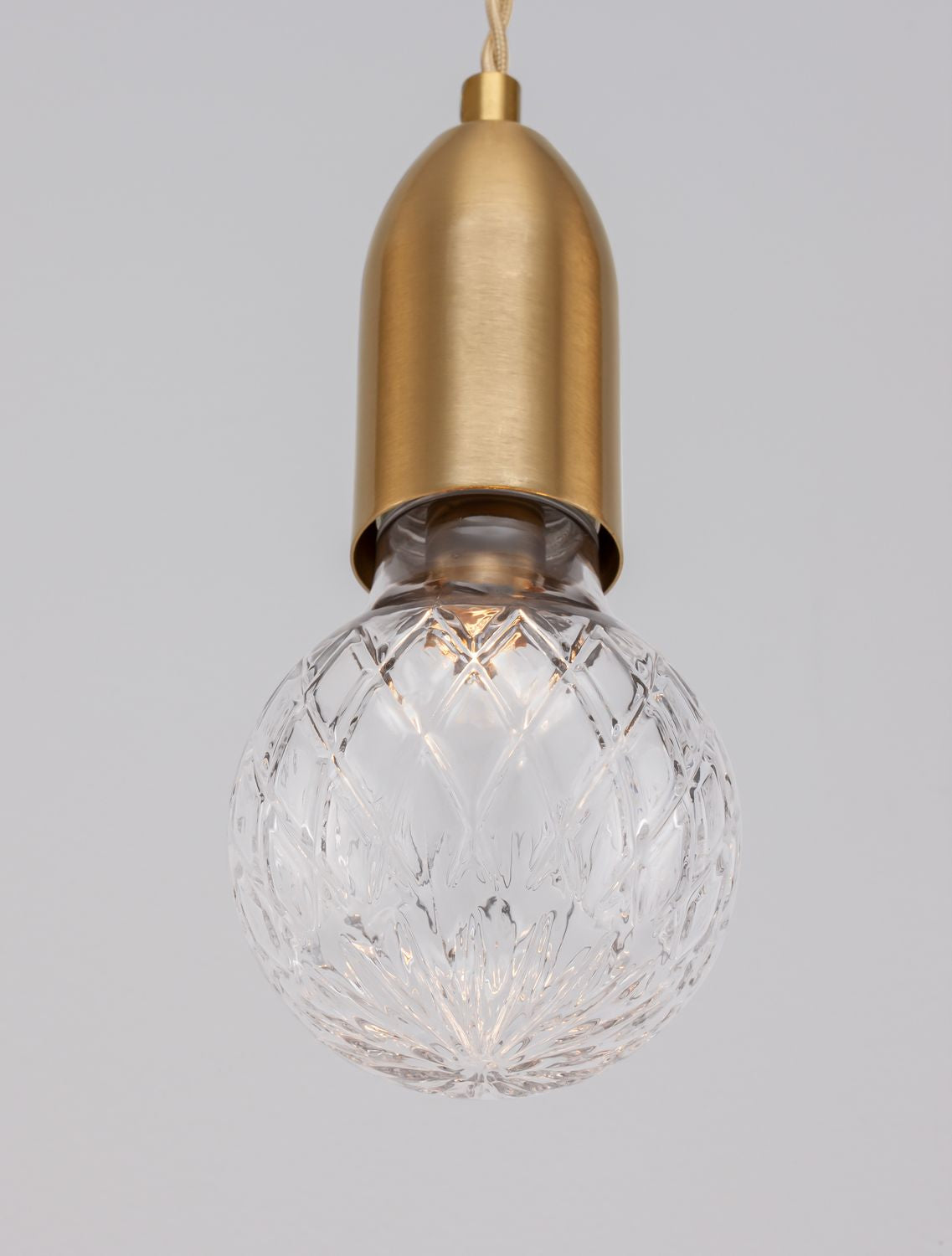 Détail rapproché de la douille laiton et du verre taillé en losanges