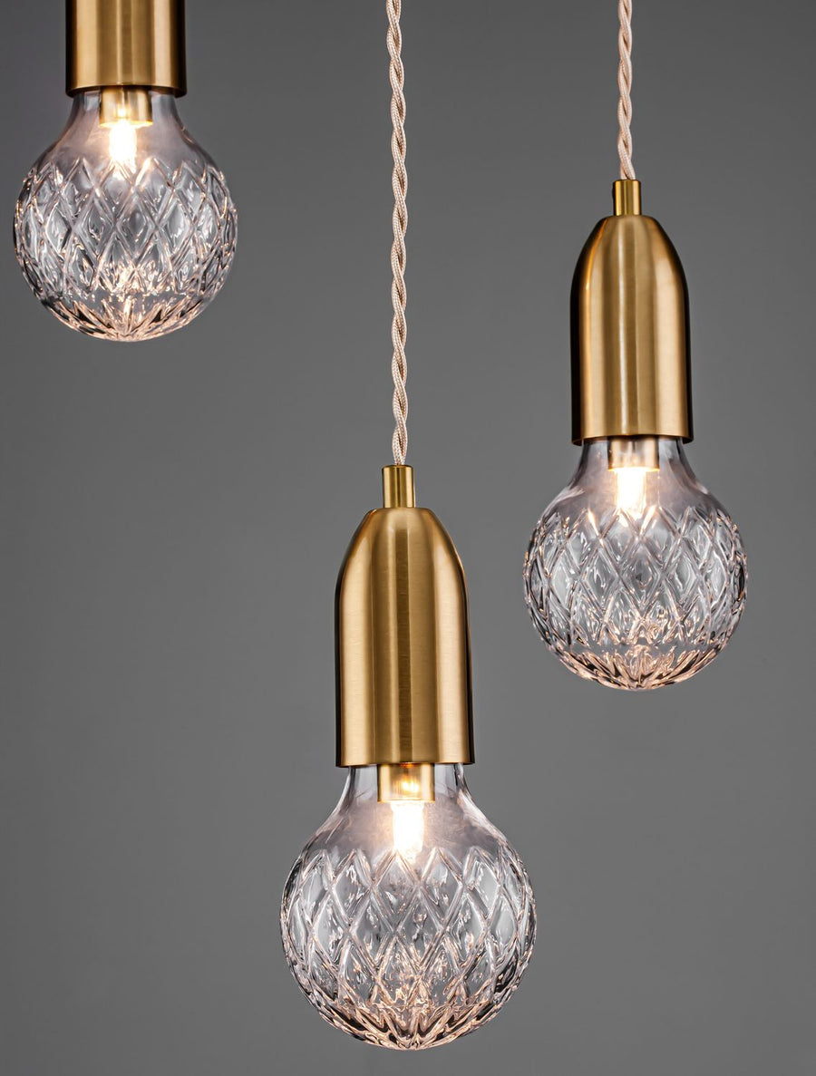 Trois globes de verre allumés sur fond gris anthracite, détail de finition