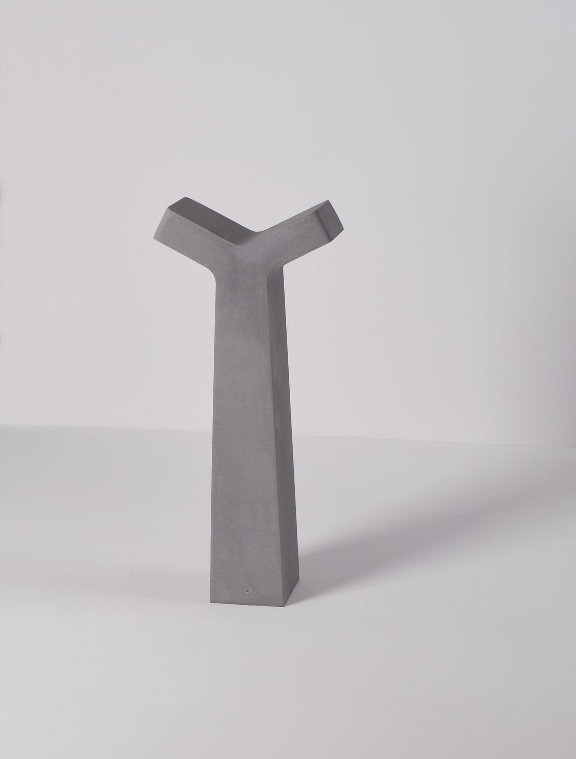 Autre angle de vue du luminaire avec ombre portée sur fond gris clair.