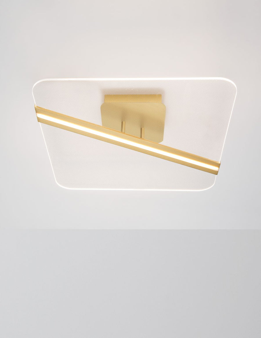 Vue de face du plafonnier allumé, diffuseur lumineux et finition dorée visible