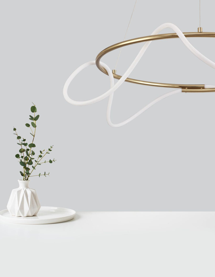 Détail du cerceau doré et du ruban lumineux blanc près d'un vase à eucalyptus