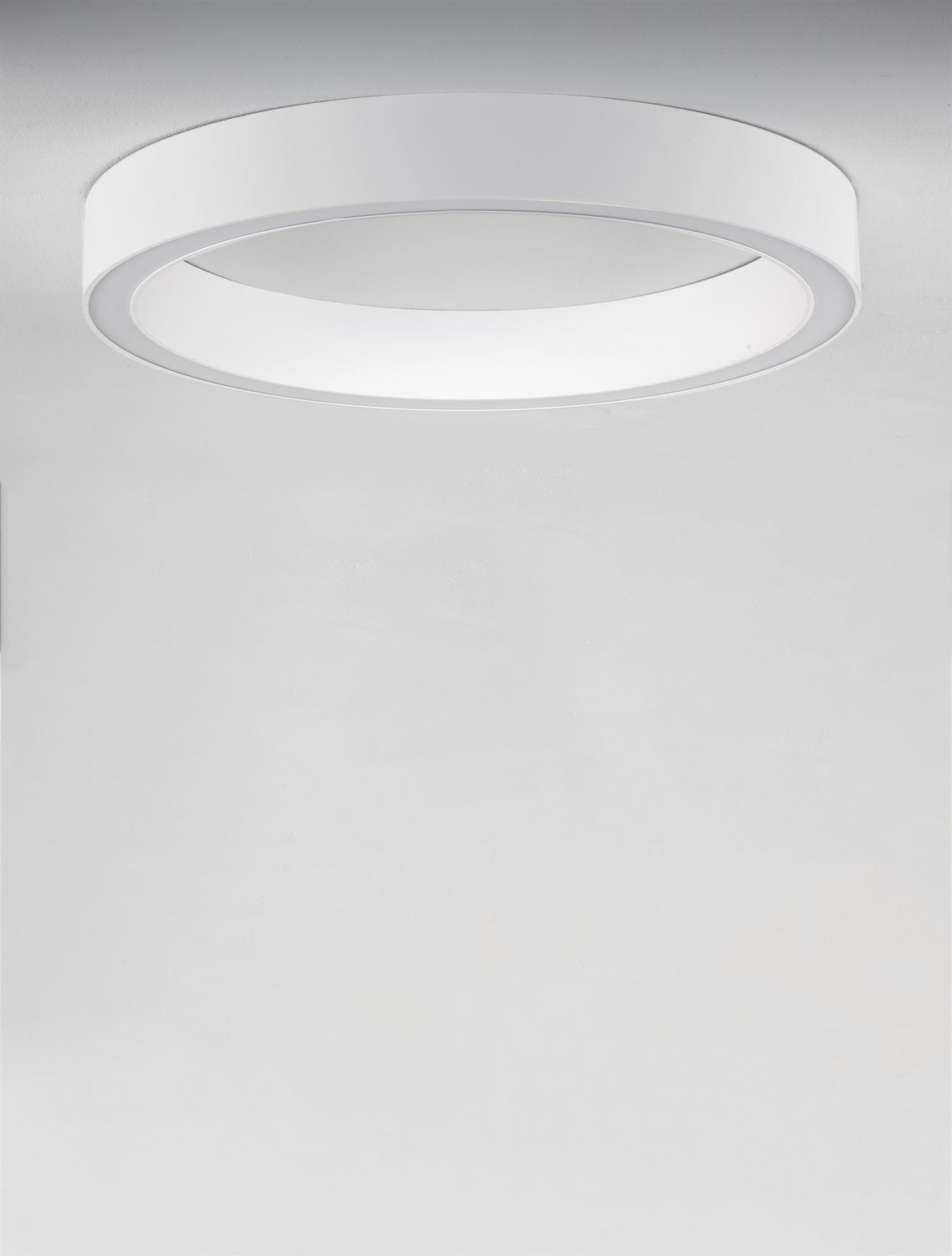 Vue du plafonnier blanc fixé au plafond, éclairé et vu de dessous.