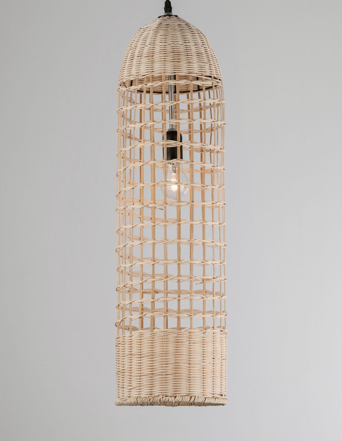Même abat-jour cylindrique en rotin, ampoule allumée diffusant une lumière chaude