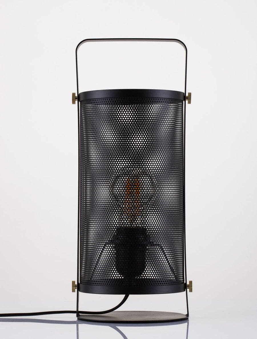 Produit de face éclairé, ampoule chaude visible derrière la grille métallique perforée