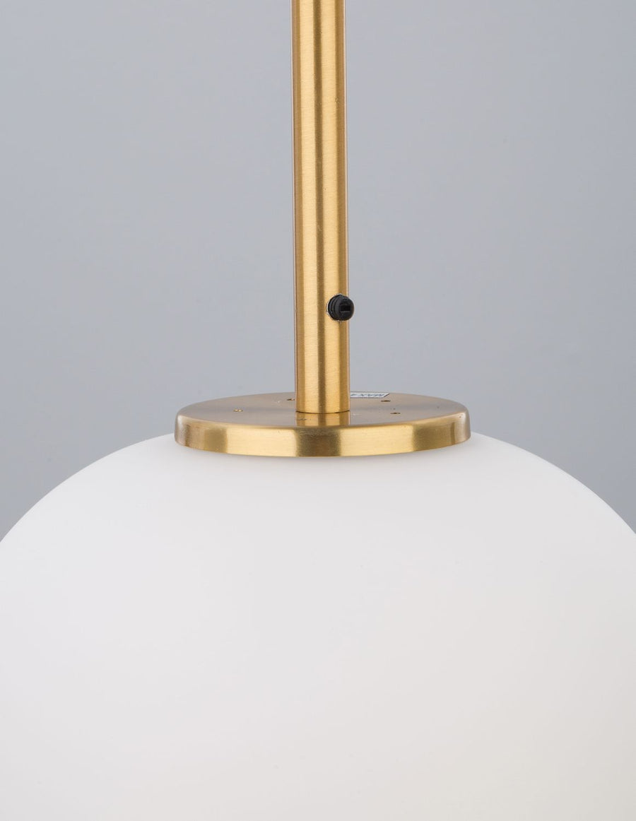 Détail du raccord doré entre la tige et le globe de verre blanc