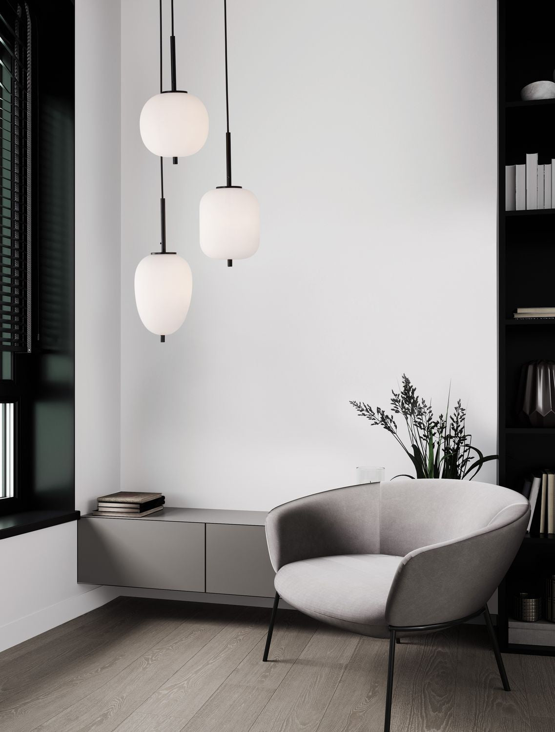 Mise en ambiance salon : suspension trois verres opale allumés au-dessus d'un fauteuil gris