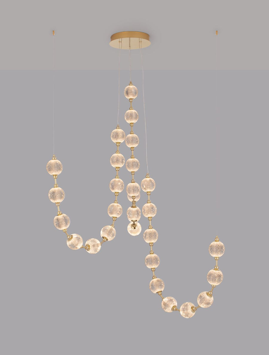 Détail des intercalaires dorés reliant chaque boule de verre texturé