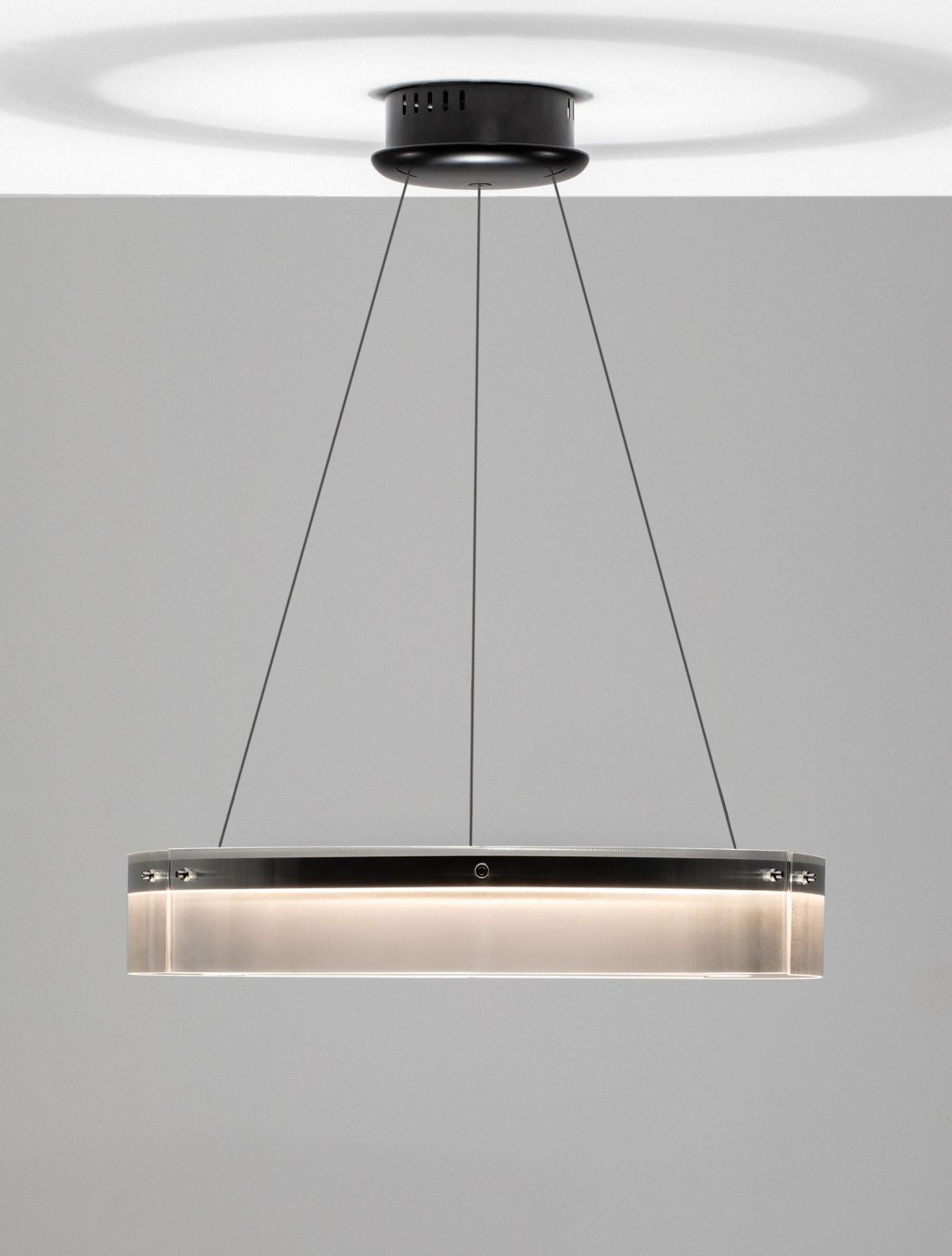 Suspension éclairée vue de face, bandeau lumineux chaud dans le verre strié