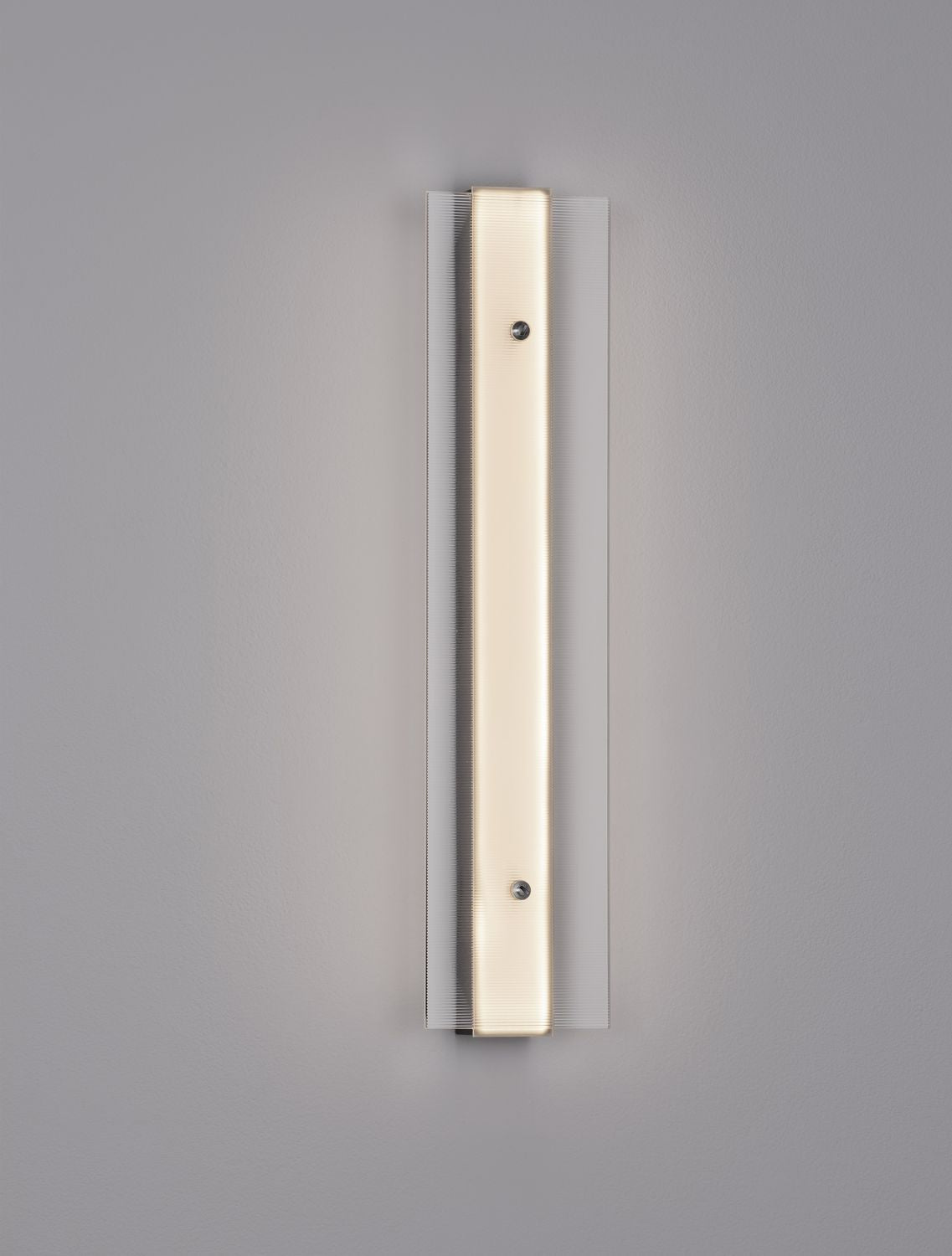 Vue de face de l'applique dorée sur fond gris, verre strié vertical.