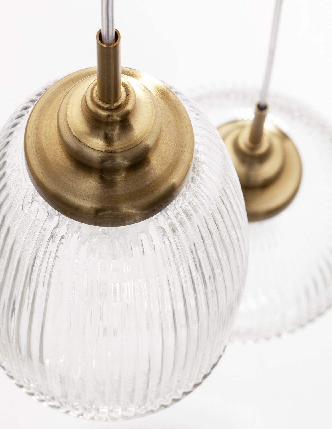 Détail de la fixation dorée et du câble blanc de la suspension
