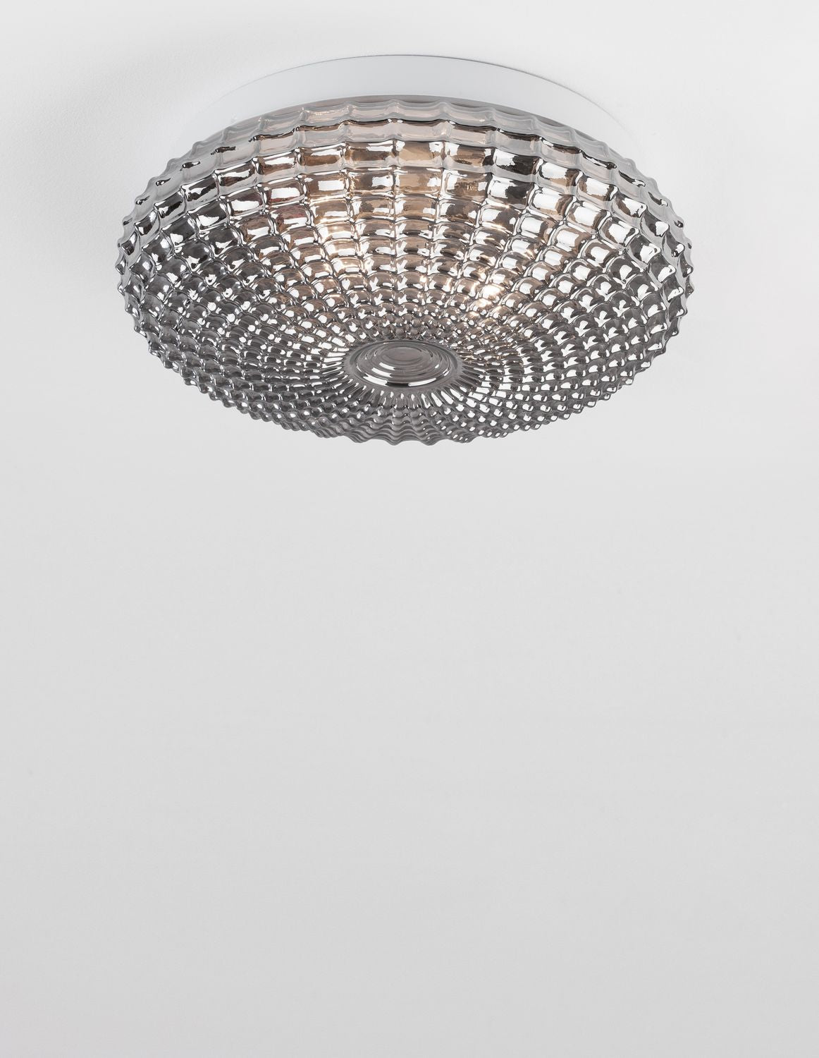 Plafonnier allumé diffusant une lumière chaude dans une pièce blanche