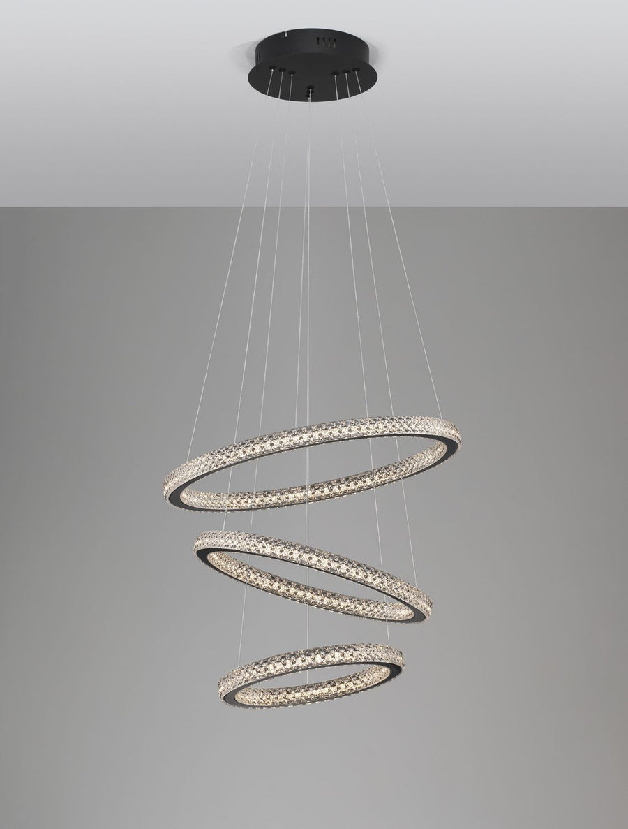 Luminaire allumé sur fond gris, cercles strassés diffusant une lumière chaude