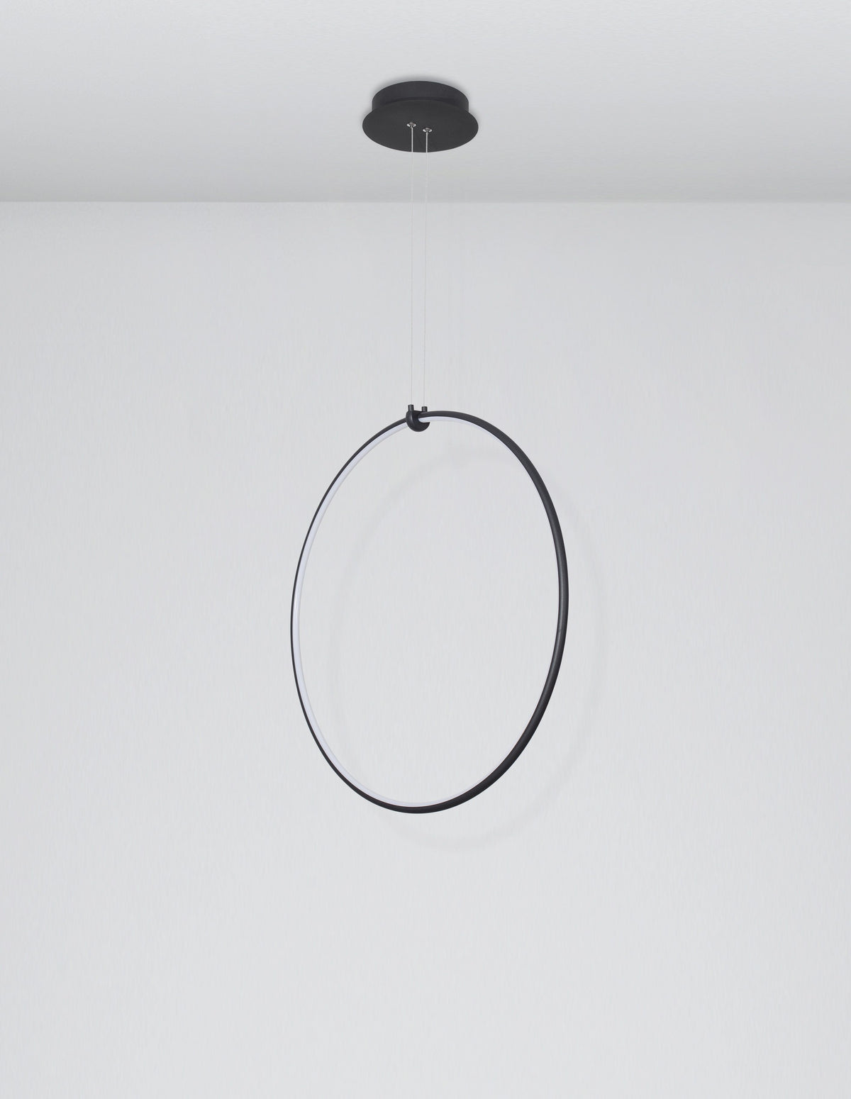 Vue de face du luminaire anneau noir suspendu devant un mur gris clair