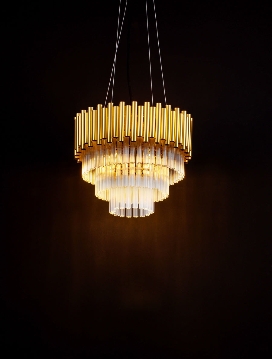 Luminaire suspendu allumé dans l'obscurité, révélant ses reflets dorés et cristallins