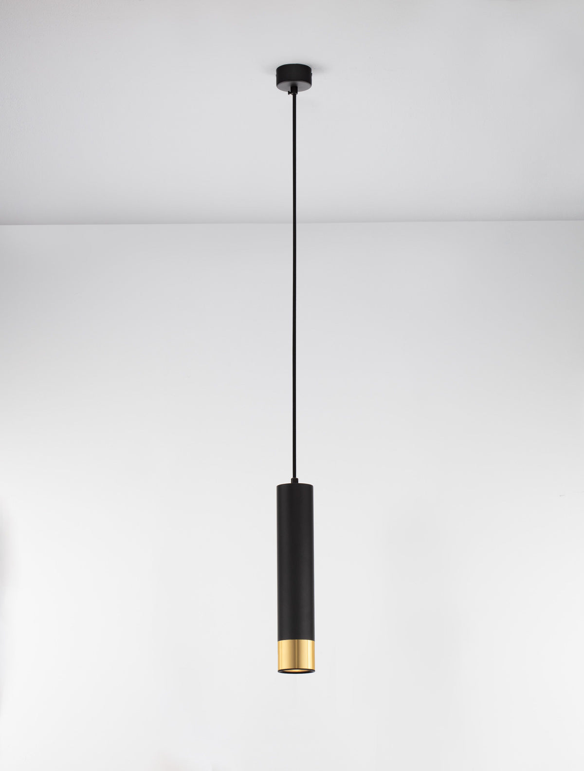 Suspension vue de face sur fond clair, cylindre noir avec bas doré