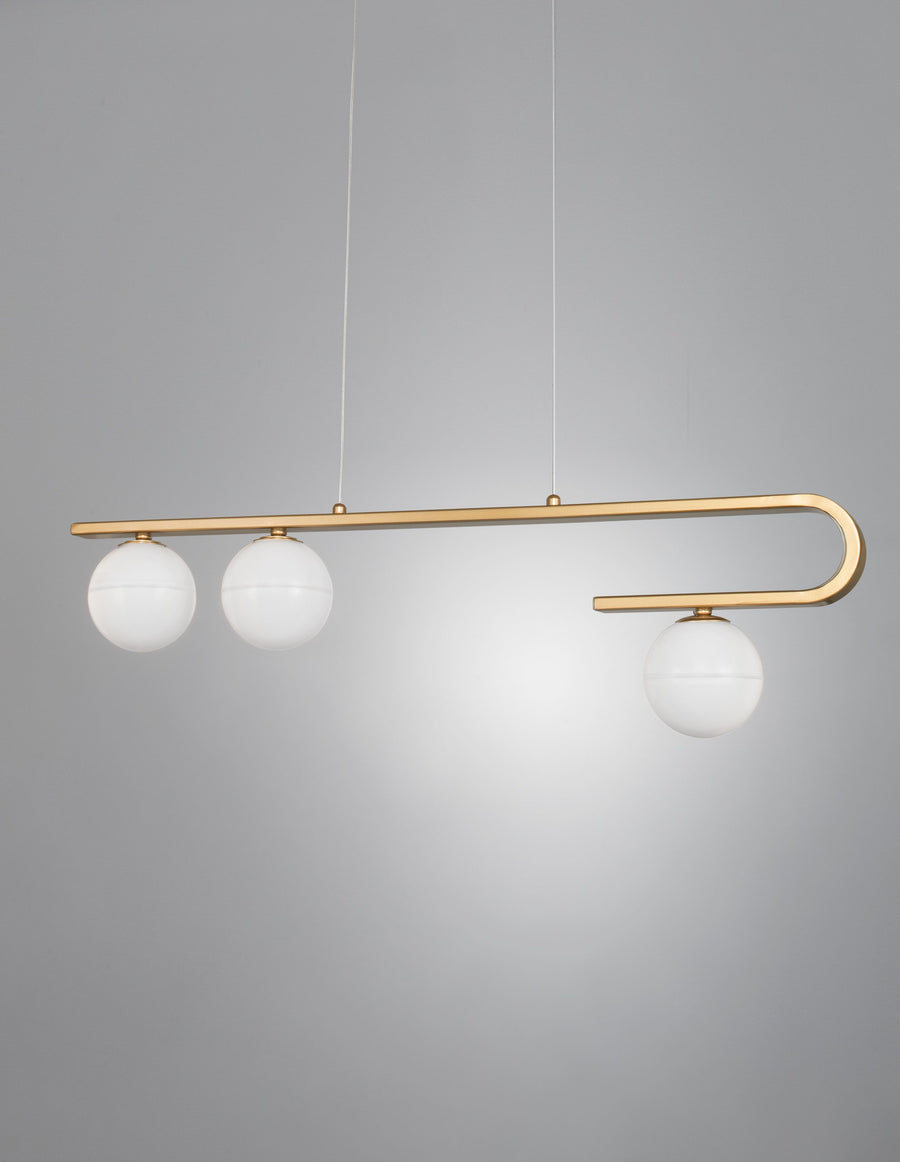 Détail du luminaire suspendu, bras doré recourbé et trois globes opalins