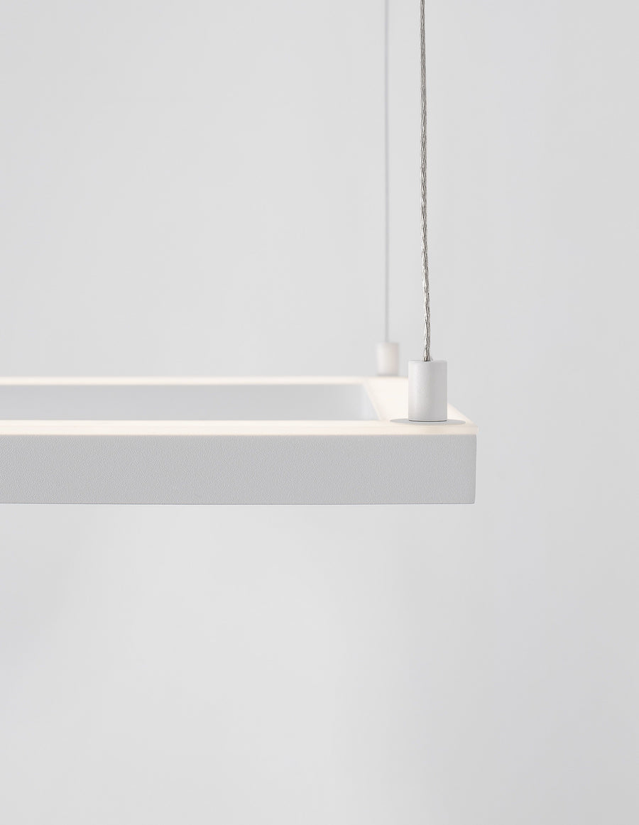 Détail du coin du cadre carré blanc, finition textile et câble de suspension