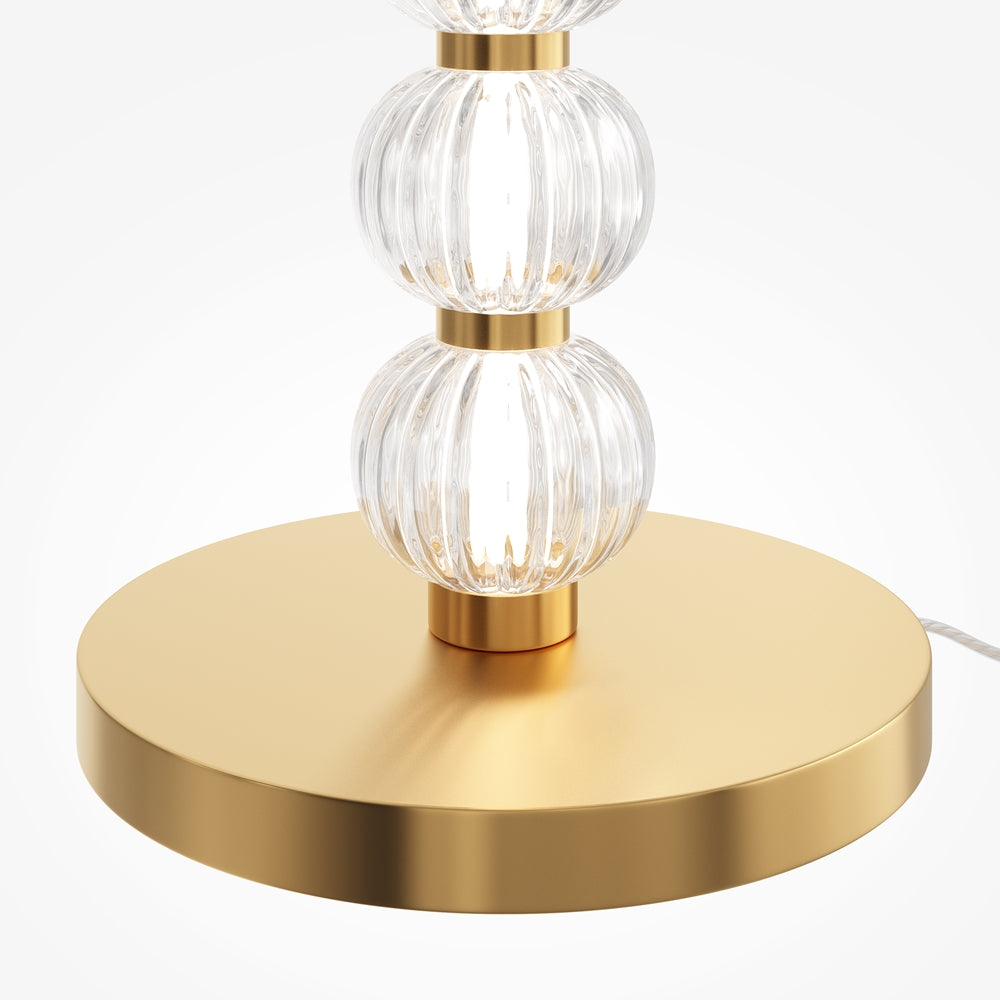 Détail de la base ronde dorée et des premiers globes de verre