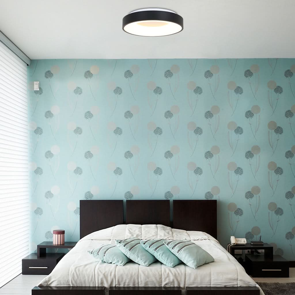 Plafonnier allumé fixé au plafond d'une chambre au papier peint bleu