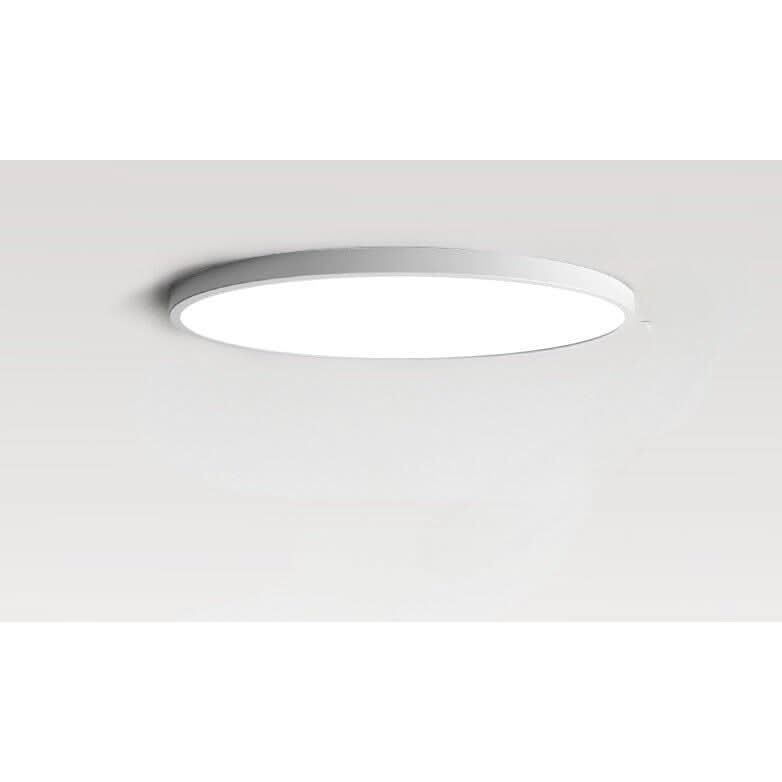 Gros plan du plafonnier rond blanc fixé au plafond, bord fin et diffuseur lumineux