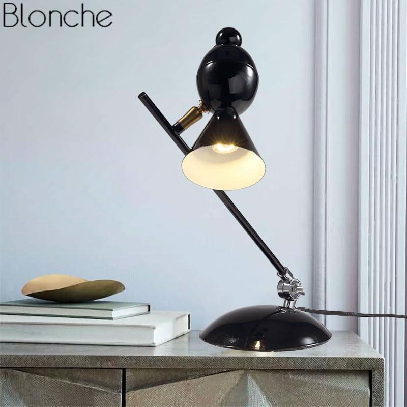 Mise en ambiance : lampe noire allumée sur un meuble, livres et coupelle décorative à côté.