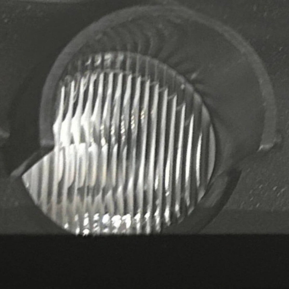 Gros plan sur la lentille striée et le réflecteur interne d'un module LED