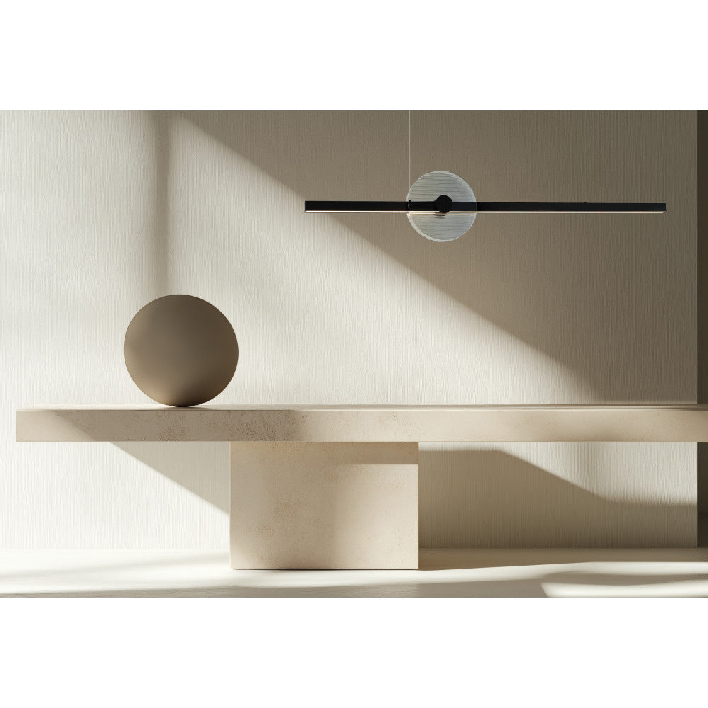 Mise en ambiance du luminaire au-dessus d'une table en travertin et sphère